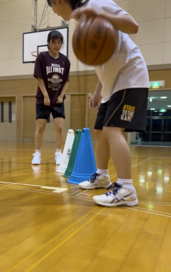 コーンを使ってドリブル練習をする女子クラス