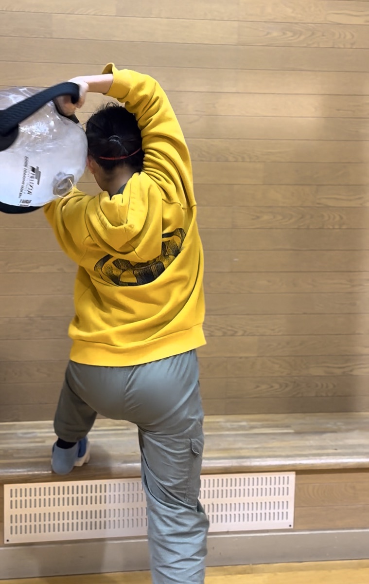 ウォーターバッグを頭上に持ち上げる選手